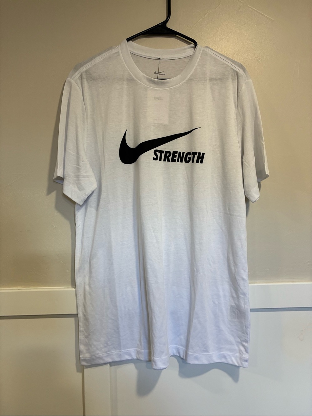 Nike White Short Sleeve Tee with Black Swoosh and 'Strength' Graphic